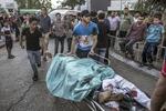 Z izby przyjęć do kostnicy. Palestyńczycy transportują ciała dwójki dzieci - ofiar poniedziałkowego nalotu na szpital i plac zabaw. Fot. PAP / EPA