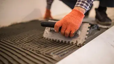 laying-ceramic-tiles-troweling-mortar-onto-concrete-floor-preparation-laying-white-floor-tile.webp